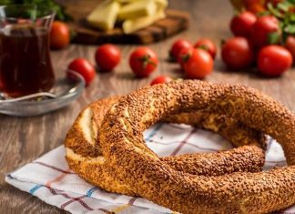 Simit ve Açma Kültürü Şehir Hayatında Değişmeyen Lezzetler Türkiye’de sokak lezzetleri denildiğinde akla gelen ilk tatlar arasında simit ve açma yer alır. Günün her saatinde ulaşılabilen bu iki hamur işi, yalnızca pratik bir atıştırmalık olmanın ötesinde, şehir yaşamının ritmini belirleyen önemli unsurlardan biri olarak görülür. Sabah işe yetişmeye çalışan bir memurun elinde, okul yolunda koşan bir öğrencinin çantasında ya da sahil kenarında çay eşliğinde tüketilen bu lezzetler, toplumsal hafızanın da güçlü bir parçasıdır. Konulu bir haber görseli.
